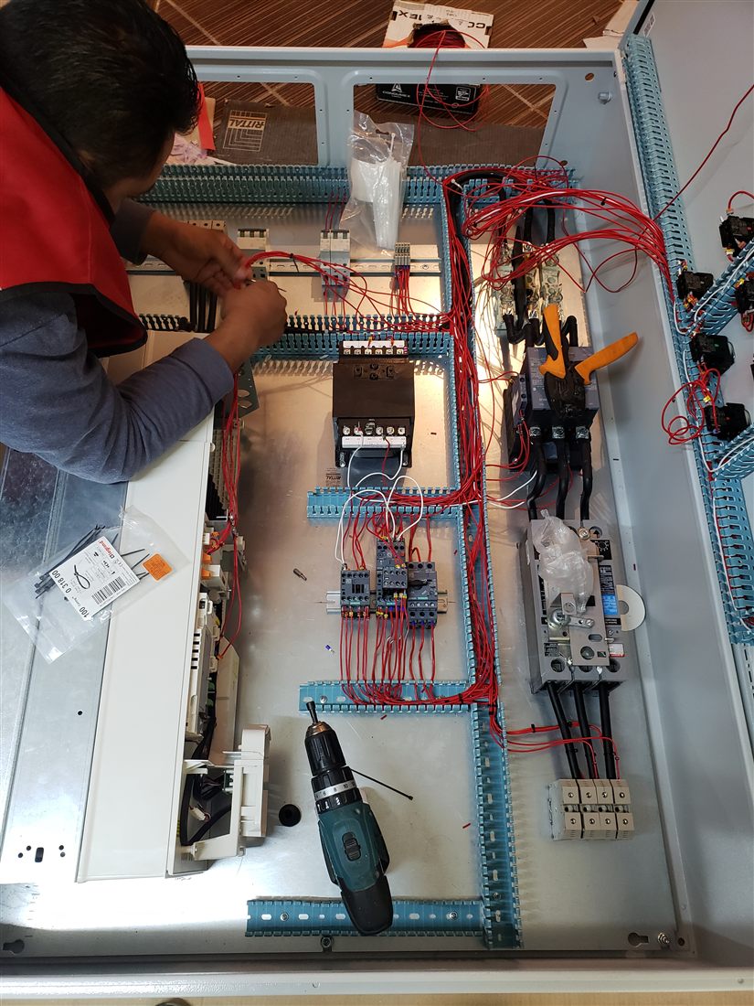 Especialista armando y cableando un tablero de control
